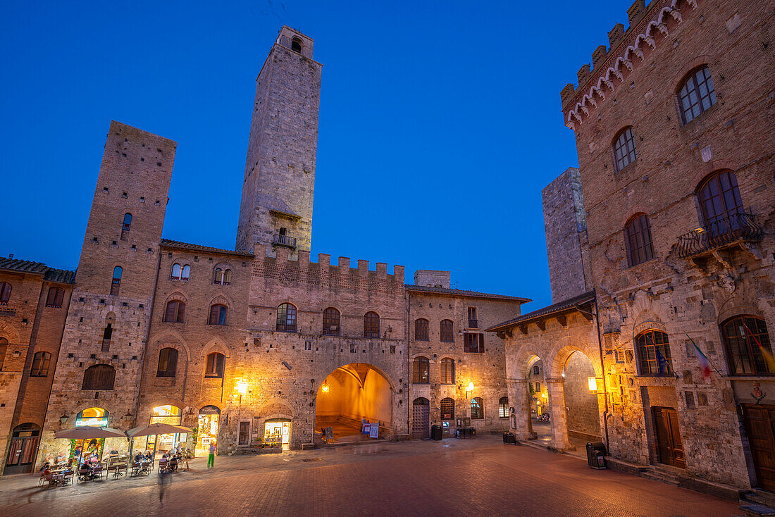 View of restaurants in Piazza del Duomo at dusk,San Gimignano,UNESCO World Heritage Site,Province of Siena,Tuscany,Italy,Europe