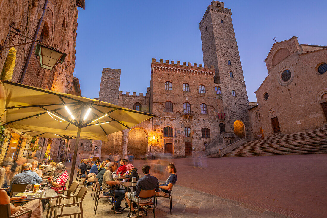 View of restaurants in Piazza del Duomo at dusk,San Gimignano,UNESCO World Heritage Site,Province of Siena,Tuscany,Italy,Europe