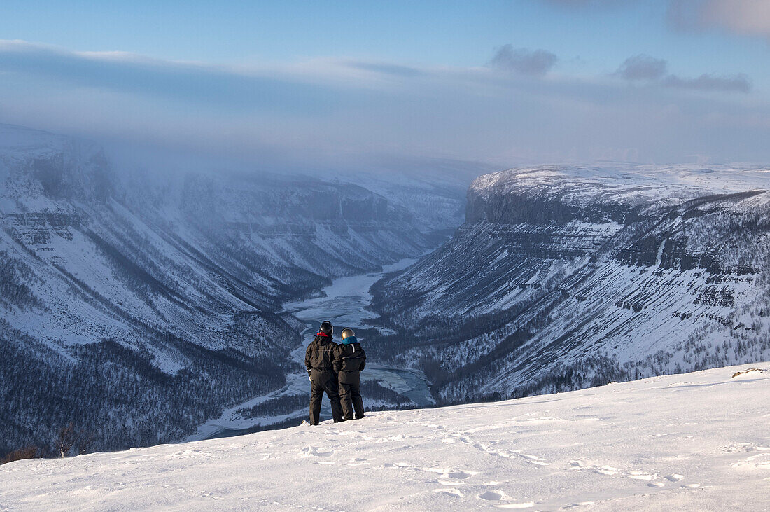 Paar in Schneeanzügen mit Blick auf die Alta-Schlucht und den Alta-Fluss von der Finnmark-Hochebene im Winter, Finnmark-Hochebene, nahe Alta, Norwegen, Polarkreis, Skandinavien, Europa