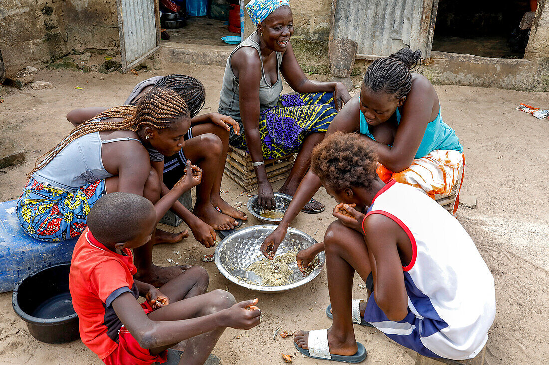 Eine Familie teilt sich eine Mahlzeit in einem Dorf in der Nähe von Fatick, Senegal, Westafrika, Afrika
