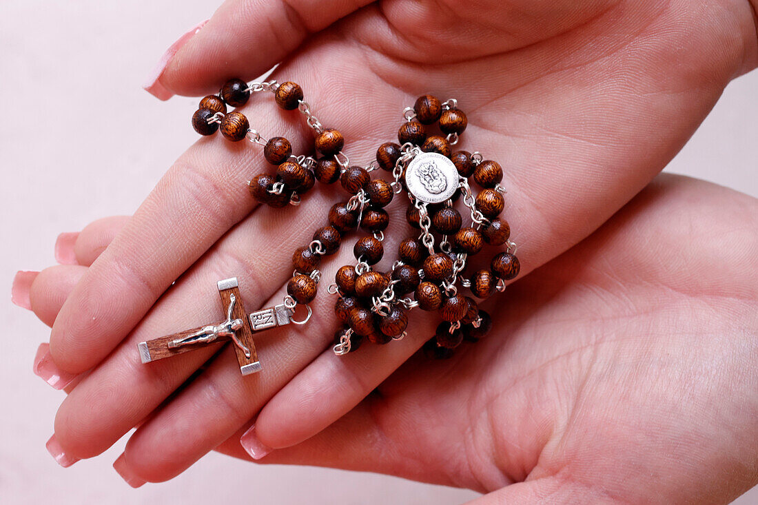 Woman's hands holding wood Catholic rosary in prayer,Vietnam,Indochina,Southeast Asia,Asia