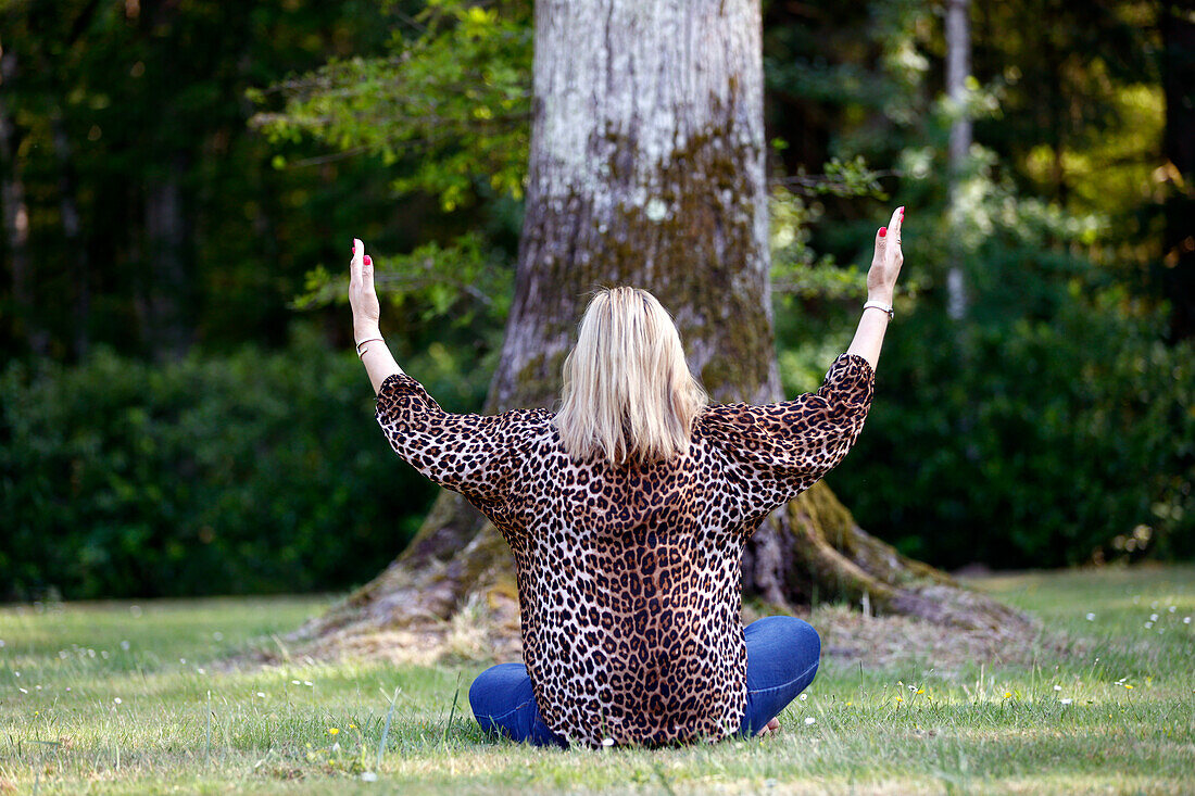 Christian woman spending personal time in and praying outdoors in a park,France,Europe