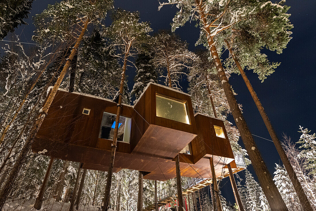 Nachtansicht einer aufgehängten Holzhütte im schneebedeckten Wald, Harads, Lappland, Schweden, Skandinavien, Europa
