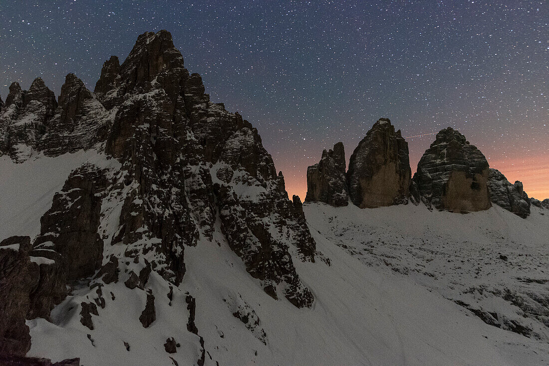 Starry night over Tre Cime di Lavaredo (Lavaredo peaks) and Paterno mountain,winter view,Sesto (Sexten),Dolomites,South Tyrol,Italy,Europe