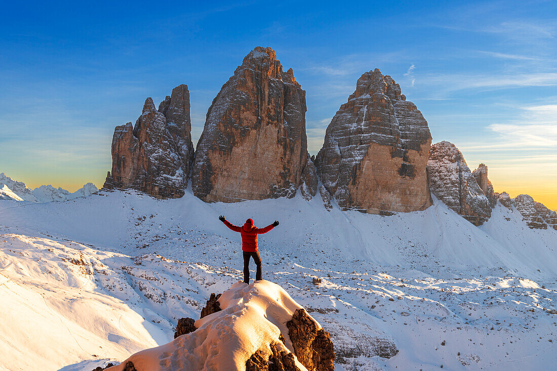 Happy hiker enjoys the view of the Tre Cime di Lavaredo at sunset,winter view,Tre Cime di Lavaredo (Lavaredo peaks) (Drei Zinnen),Sesto (Sexten),Dolomites,South Tyrol,Italy,Europe