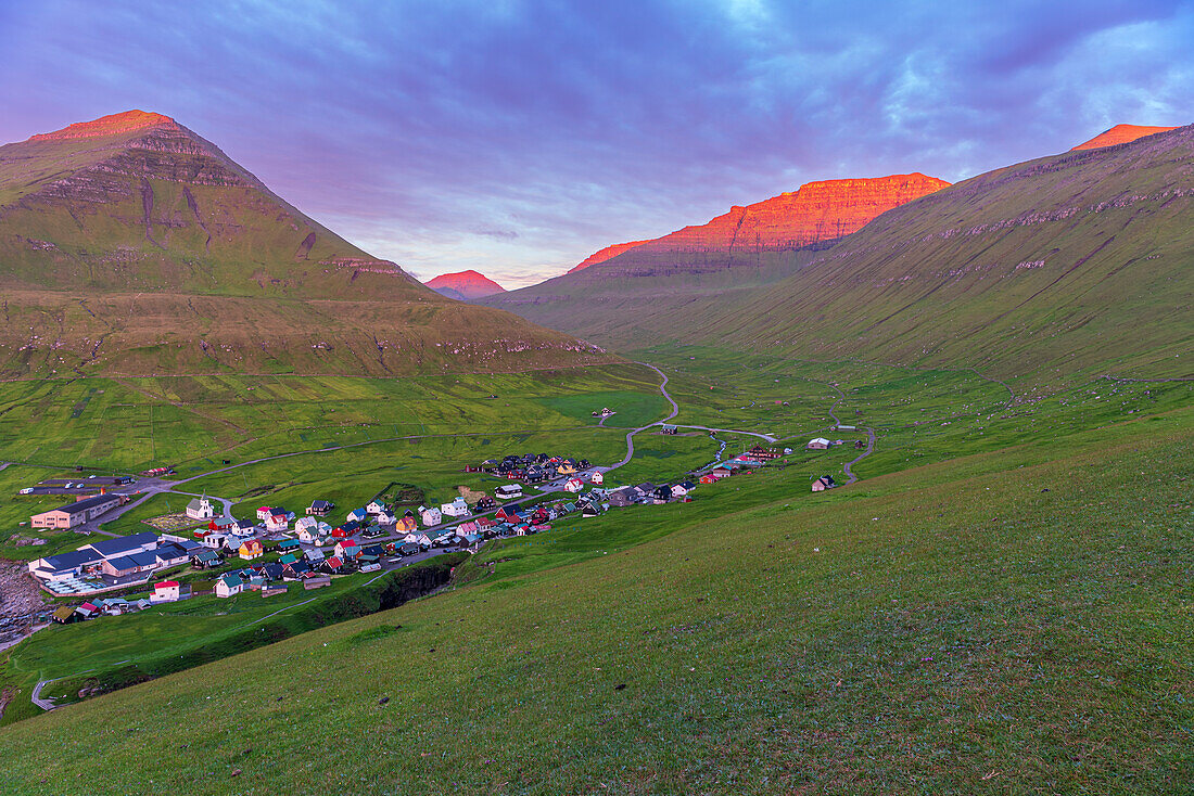 Früher Morgen im Dorf Gjogv mit den von der Sonne beleuchteten Berggipfeln, Insel Eysturoy, Färöer Inseln, Dänemark, Europa