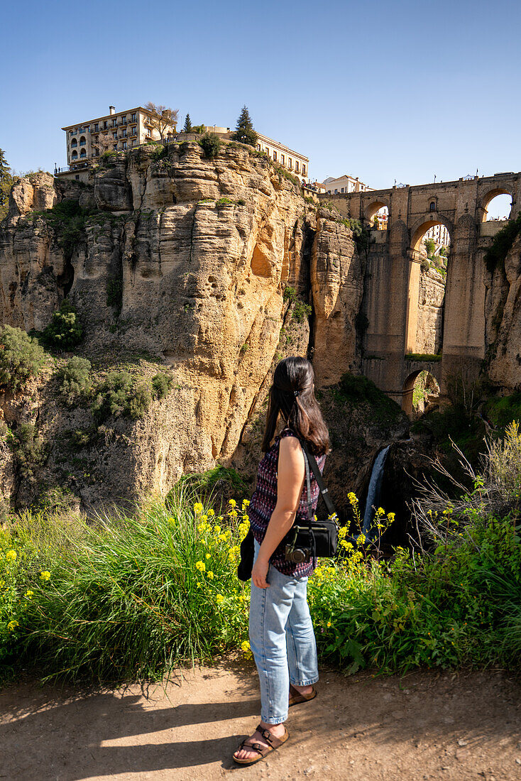 Frau schaut auf die historische Brücke von Ronda, Pueblos Blancos, Andalusien, Spanien, Europa