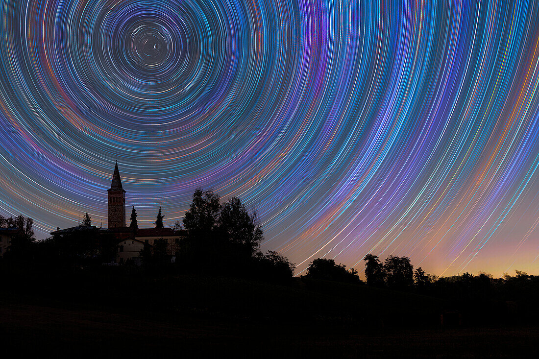 Konzentrischer Sternenschweif über einem Glockenturm in der italienischen Landschaft, Emilia Romagna, Italien, Europa