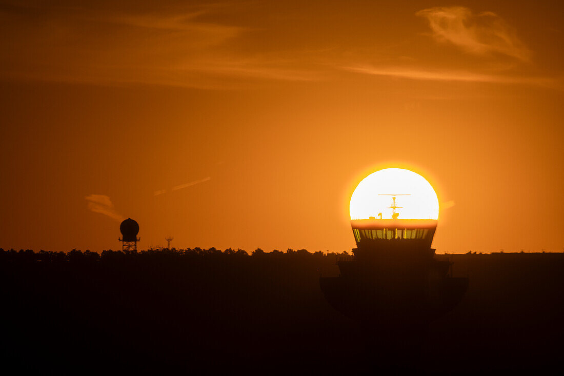 The sun aligned at sunrise with an airport control tower,Spain,Europe