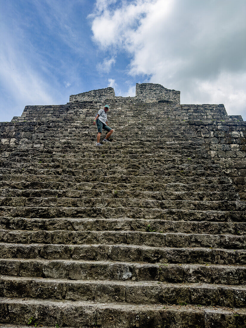 Ein Tourist auf der Struktur 1 der Malergruppe oder Plaza of the Shadows in den Maya-Ruinen im Yaxha-Nakun-Naranjo-Nationalpark, Guatemala.