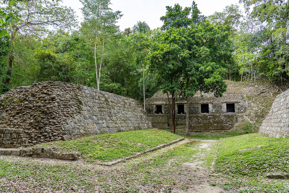 Ballspielplatz I auf der Plaza D der Maya-Ruinen im Yaxha-Nakun-Naranjo-Nationalpark, Guatemala. Struktur 389 auf der südlichen Akropolis dahinter.