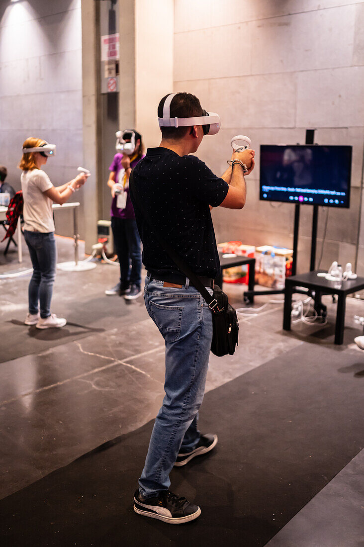 Junger Mann spielt mit Meta Quest 2 All-in-One VR-Headset während ZGamer, einem Festival für Videospiele, digitale Unterhaltung, Brettspiele und YouTuber während der Fiestas von El Pilar in Zaragoza, Aragonien, Spanien