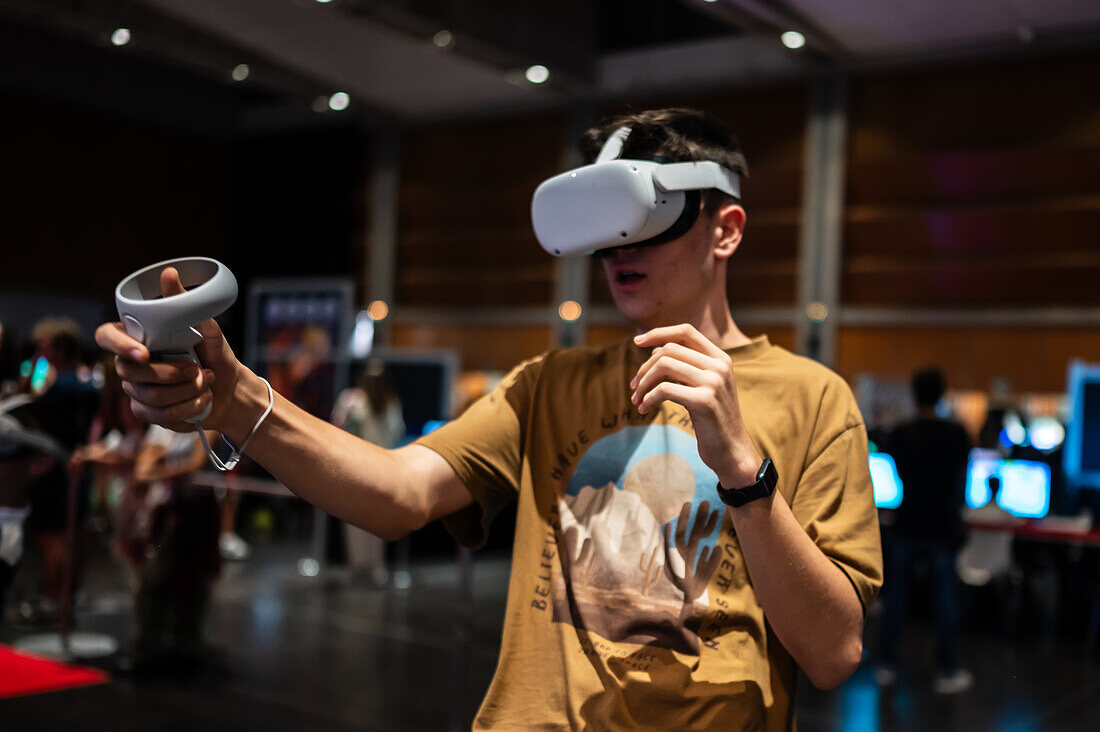Teenager spielt mit dem Meta Quest 2 All-in-One VR-Headset während des ZGamer, einem Festival für Videospiele, digitale Unterhaltung, Brettspiele und YouTuber während der El Pilar Fiestas in Zaragoza, Aragonien, Spanien