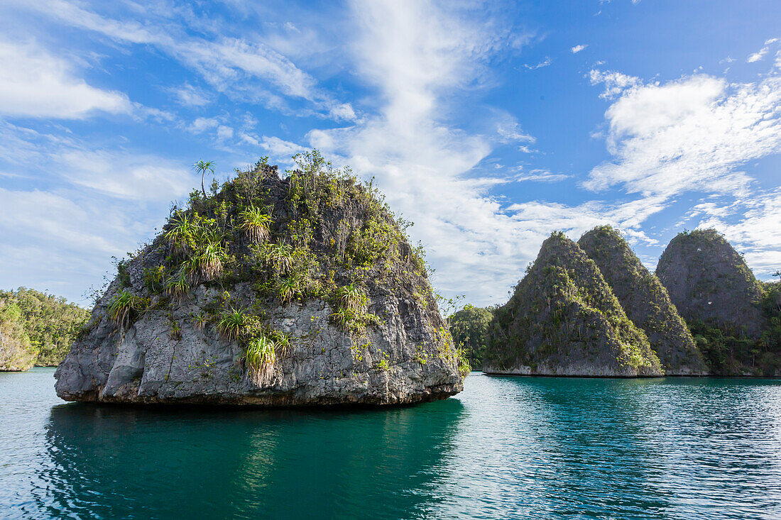 Blick auf bewachsene Inselchen im geschützten Naturhafen in der Wayag-Bucht, Raja Ampat, Indonesien, Südostasien, Asien