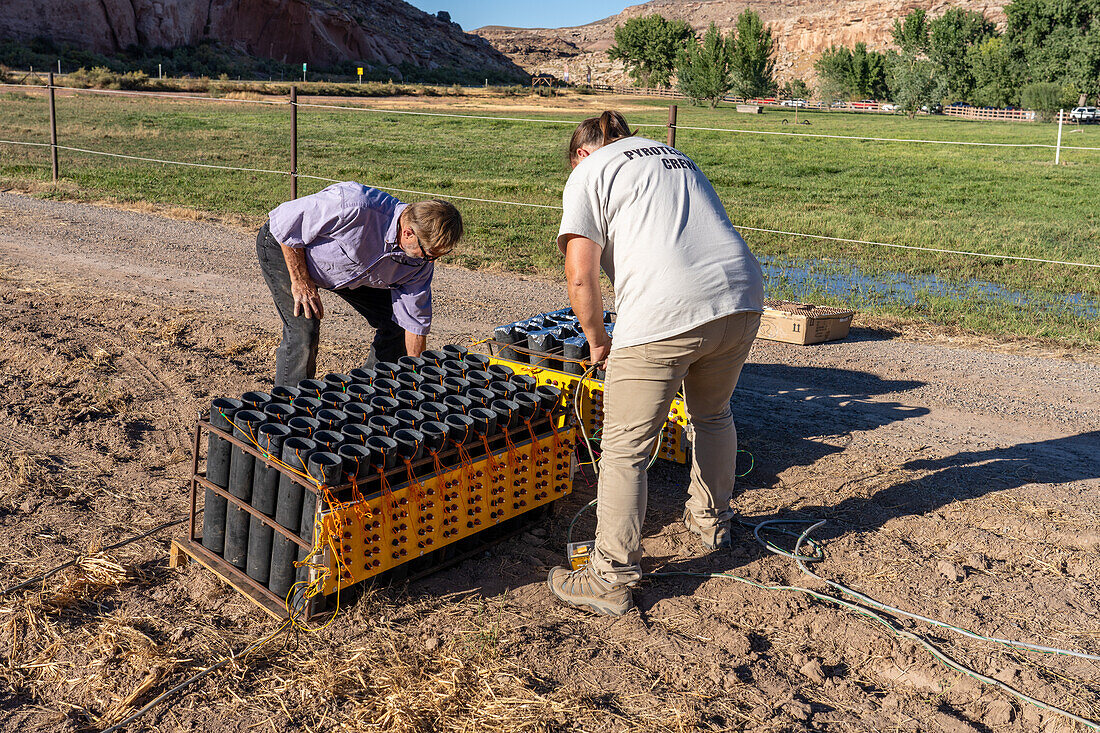 Techniker richten eine Batterie von Abschussvorrichtungen für 4-Zoll-Pyrotechnikgranaten ein, die für eine Feuerwerksshow auf einem Feld in Utah vorbereitet werden.