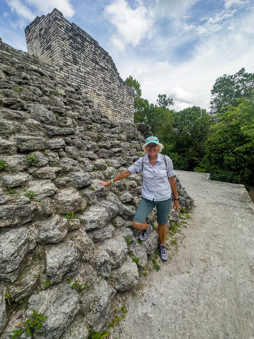 Ein Tourist auf der Struktur 1 der Malergruppe oder der Plaza of the Shadows in den Maya-Ruinen im Yaxha-Nakun-Naranjo-Nationalpark, Guatemala.