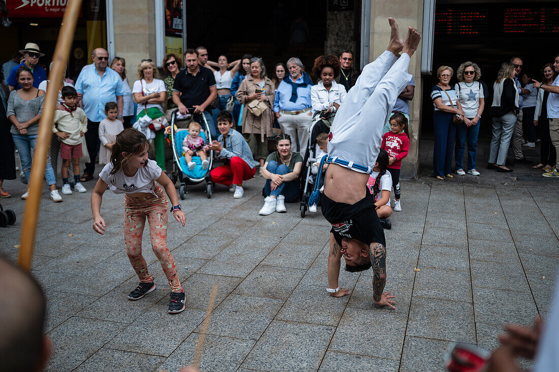 Mitglieder der Mestre Branco Capoeira Escola demonstrieren auf der Straße während der Fiestas von El Pilar in Zaragoza, Aragonien, Spanien