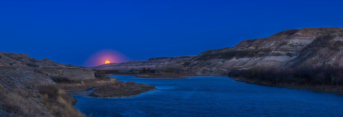 The rising Full Moon of May 5,2023,coming up over the Red Deer River near East Coulee,Alberta. This is a panorama of the Badlands scene,with the site planned with The Photographer's Ephemeris app.