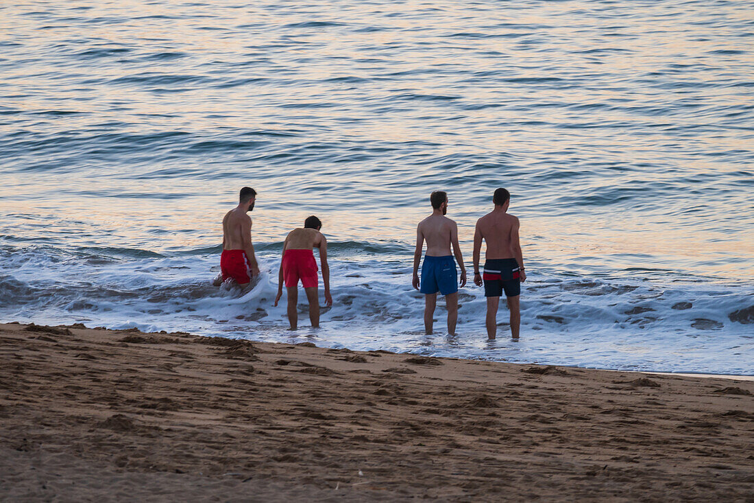 Kids on Grande Plage beach at sunset in Saint Jean de Luz,fishing town at the mouth of the Nivelle river,in southwest France’s Basque country