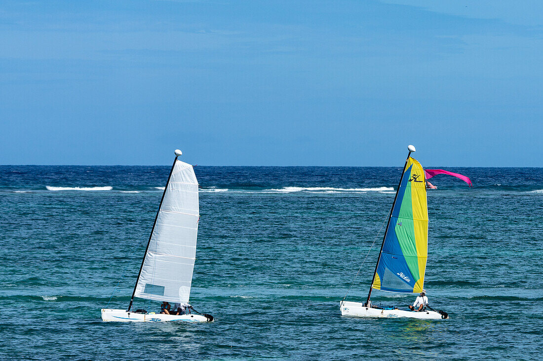 Hobie Cat Katamaran Segelboote segeln in der Karibischen See bei San Pedro auf Ambergris Caye in Belize. Dahinter ist der Wellenbrecher am Belize Barrier Reef zu sehen.