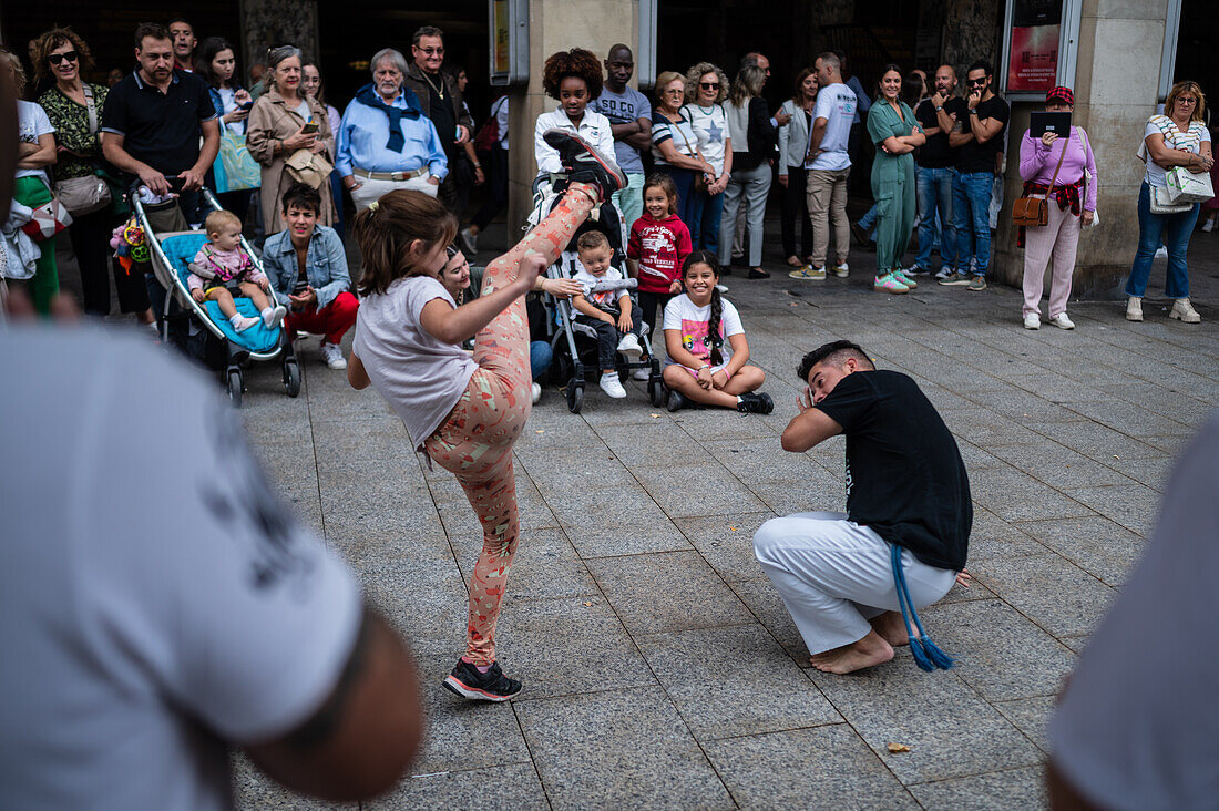 Mitglieder der Mestre Branco Capoeira Escola demonstrieren auf der Straße während der Fiestas de El Pilar in Zaragoza, Aragonien, Spanien