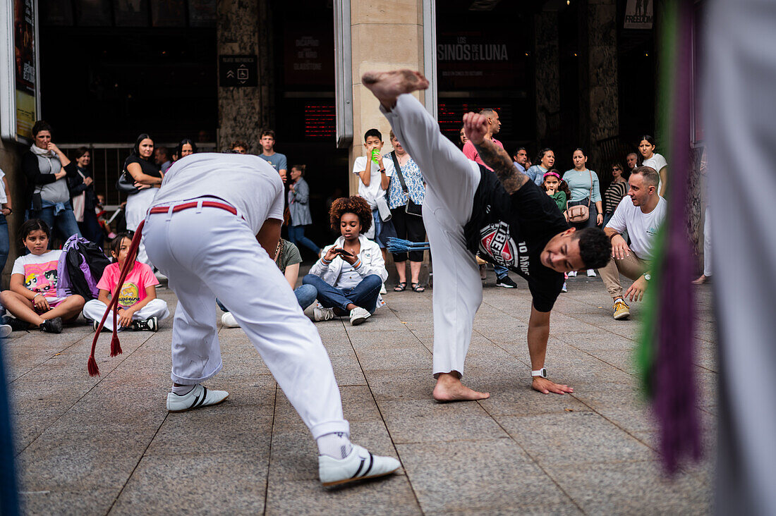 Mitglieder der Mestre Branco Capoeira Escola demonstrieren auf der Straße während der Fiestas von El Pilar in Zaragoza, Aragonien, Spanien