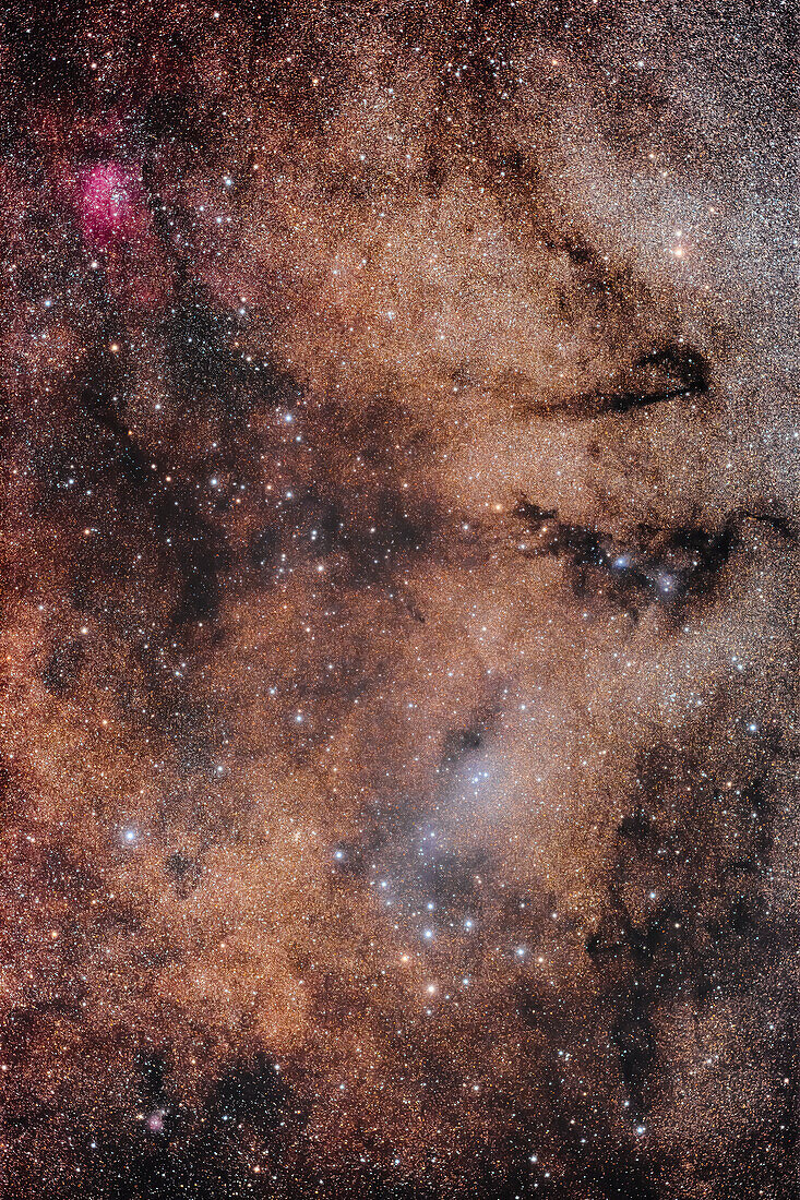 A rich starfield in the constellation of Vulpecula the Fox,in the Milky Way,with a mix of nebulosity. At bottom is the Coathanger asterism of stars,aka Collinder 399,or Brocchi's Cluster. At top left is the emission nebula NGC 6820. Other dark nebulas from the Lynds Dark Nebula catalogue populate the field. The blue glow above the Coathanger is reflection nebulosity which does not appear to have a catlogue number. A small reflection nebula around the blue stars at right is van den Burgh 126. The small round red emission nebula at lower left is Sharpless 2-82. The yellow star at top right is An