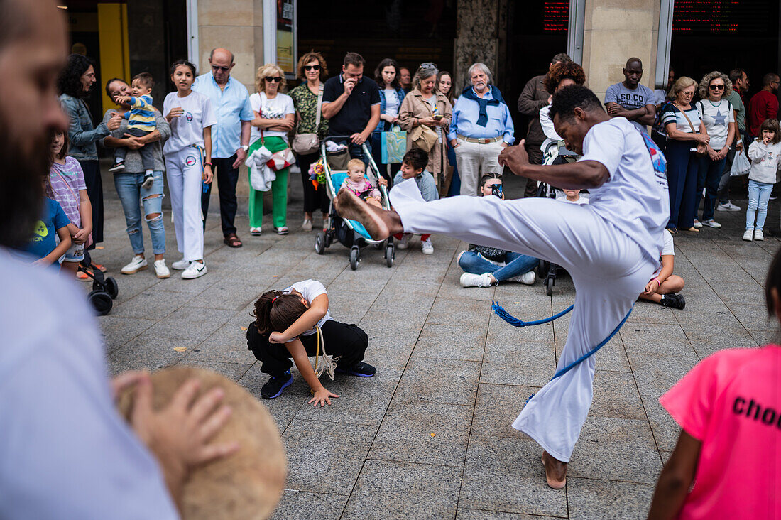 Mitglieder der Mestre Branco Capoeira Escola demonstrieren auf der Straße während der Fiestas von El Pilar in Zaragoza, Aragonien, Spanien