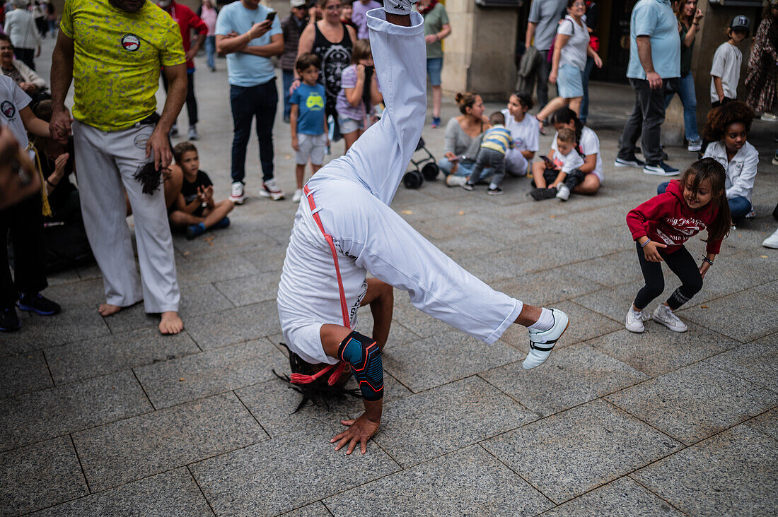 Mitglieder der Mestre Branco Capoeira Escola demonstrieren auf der Straße während der Fiestas von El Pilar in Zaragoza, Aragonien, Spanien