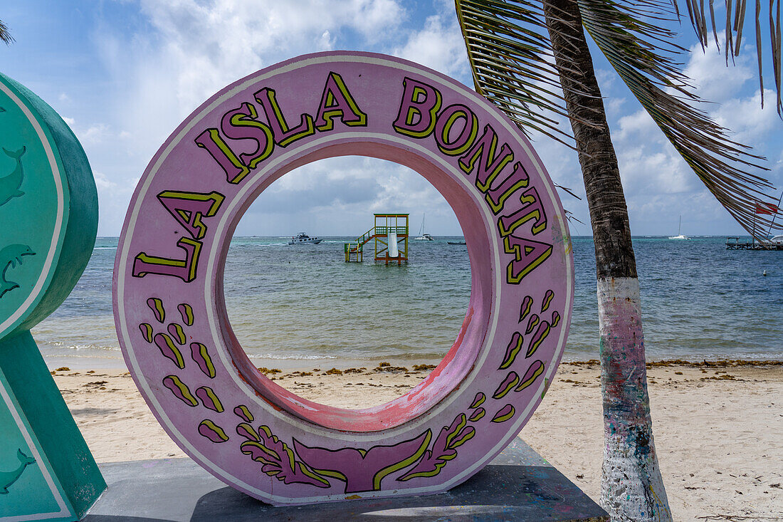 Boote auf dem Karibischen Meer, eingerahmt von einem 3-D-Schild am Strand von San Pedro auf Ambergris Caye, Belize.