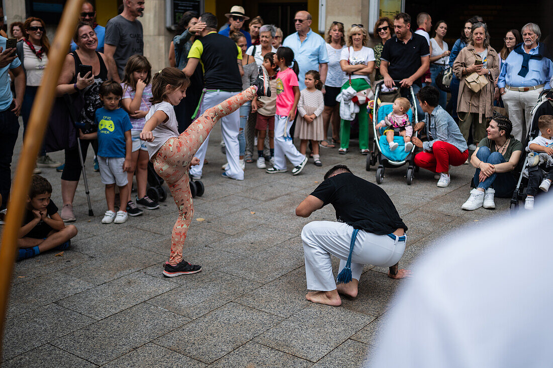 Mitglieder der Mestre Branco Capoeira Escola demonstrieren auf der Straße während der Fiestas von El Pilar in Zaragoza, Aragonien, Spanien