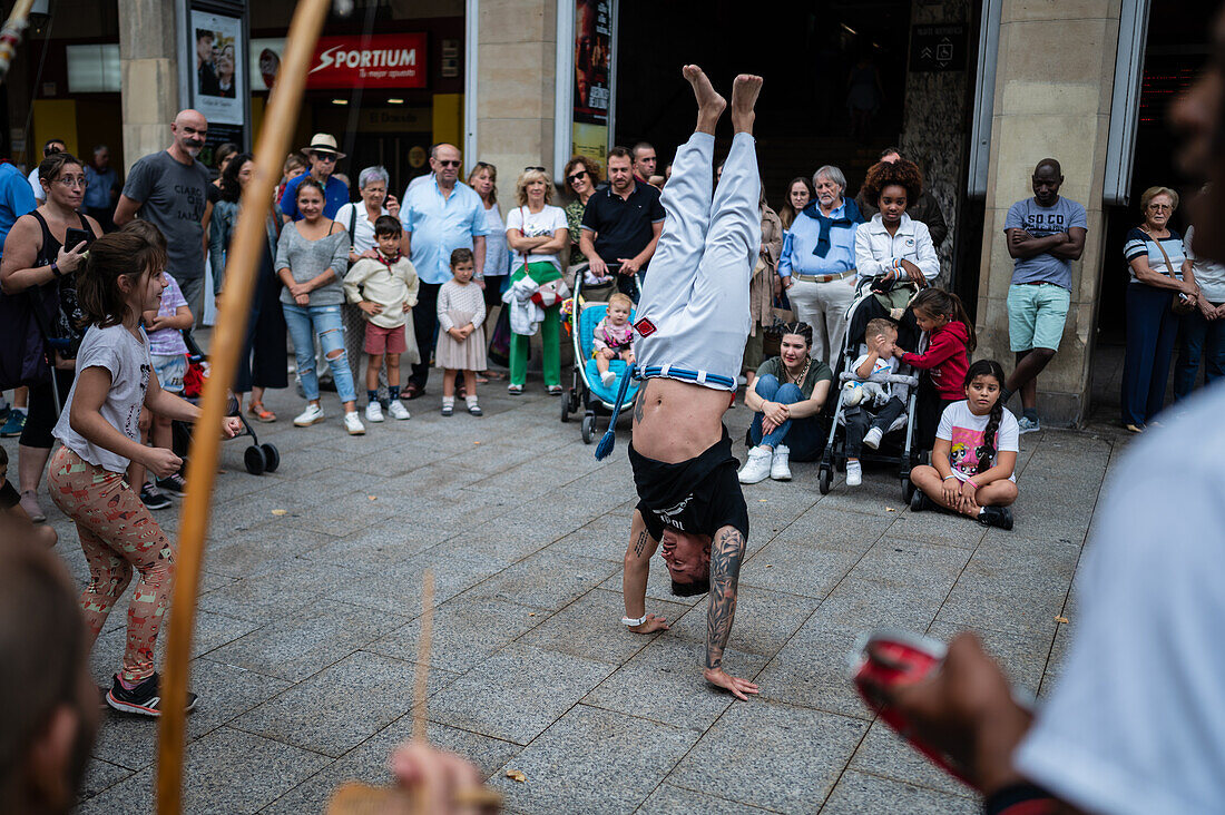 Mitglieder der Mestre Branco Capoeira Escola demonstrieren auf der Straße während der Fiestas von El Pilar in Zaragoza, Aragonien, Spanien