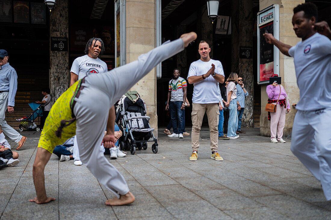 Mitglieder der Mestre Branco Capoeira Escola demonstrieren auf der Straße während der Fiestas de El Pilar in Zaragoza, Aragonien, Spanien