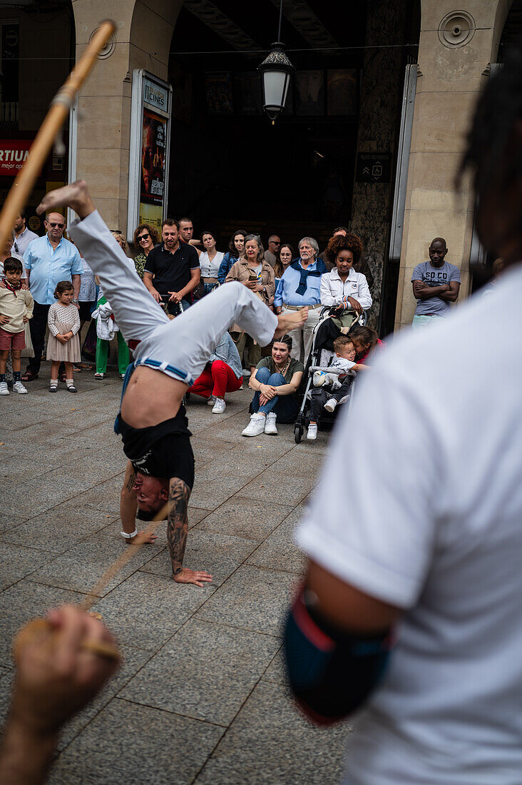 Mitglieder der Mestre Branco Capoeira Escola demonstrieren auf der Straße während der Fiestas von El Pilar in Zaragoza, Aragonien, Spanien