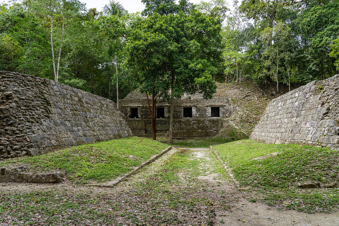 Ballspielplatz I auf der Plaza D der Maya-Ruinen im Yaxha-Nakun-Naranjo-Nationalpark, Guatemala. Struktur 389 in der südlichen Akropolis dahinter.