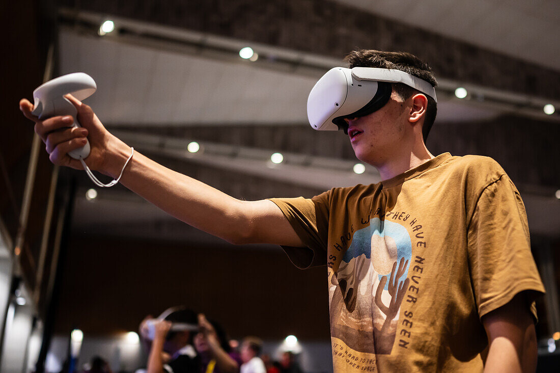 Teenager spielt mit dem Meta Quest 2 All-in-One VR-Headset während des ZGamer, einem Festival für Videospiele, digitale Unterhaltung, Brettspiele und YouTuber während der Fiestas von El Pilar in Zaragoza, Aragonien, Spanien