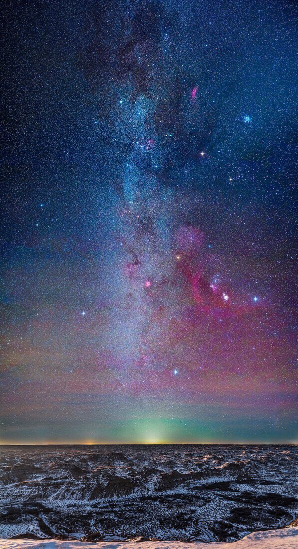 A panorama of the Milky Way on a February winter night over the Badlands of Dinosaur Provincial Park,Alberta. The panorama extends from Canis Major low on the horizon to Perseus at top near the zenith. Orion is at right of centre,with Gemini to the left and Taurus and Auriga above Orion. Mars is the bright reddish object in Taurus aboce similarly coloured but dimmer Aldebaran,itself amid the Hyades star cluster. The blue Pleiades is at upper right. Sirius is the bright star at bottom. The image takes in the complete Winter Hexagon (aka the Winter Circle) of bright stars.