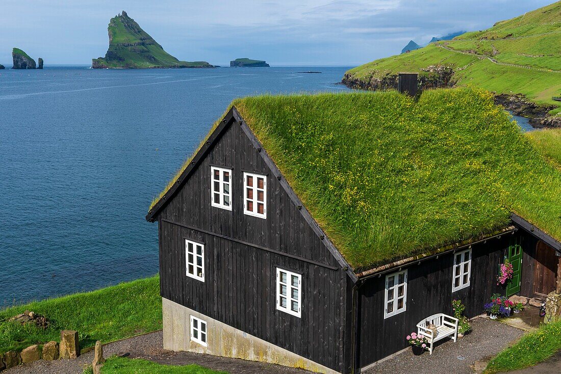 Dänemark, Färöer Inseln, Insel Vagar, Dorf Bour, Haus und Insel Tindholmur im Hintergrund