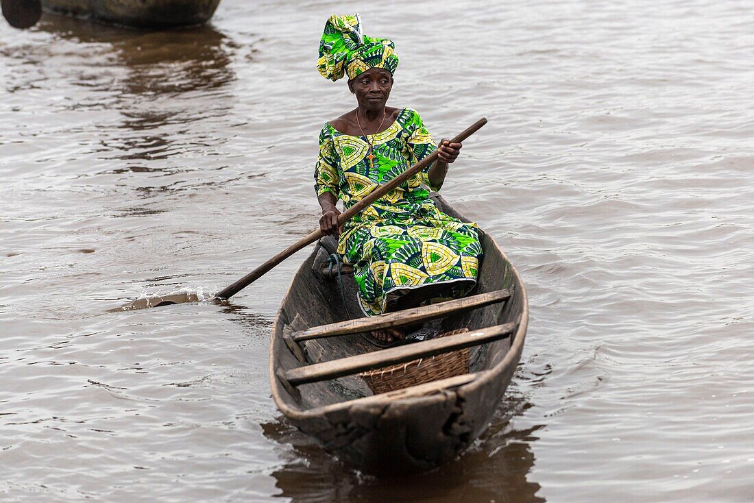 Benin, lakeside city of Ganvié, woman on boat