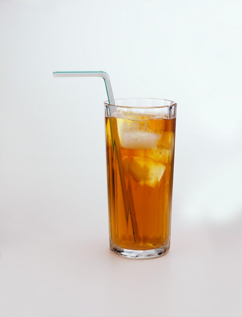 A glass of iced tea with ice cubes and straw
