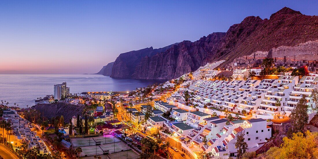 Spanien, Kanarische Inseln, Teneriffa, Los Gigantes, Wohnungen in den Bergen und Küstenklippen, Blick von oben, Abenddämmerung