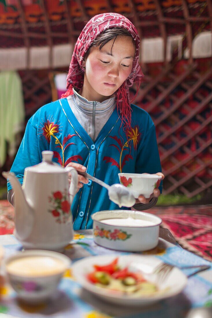 Kyrgyzstan, Naryn province, Son-Kol lake, altitude 3000m, girl serving yogurt in a yurt