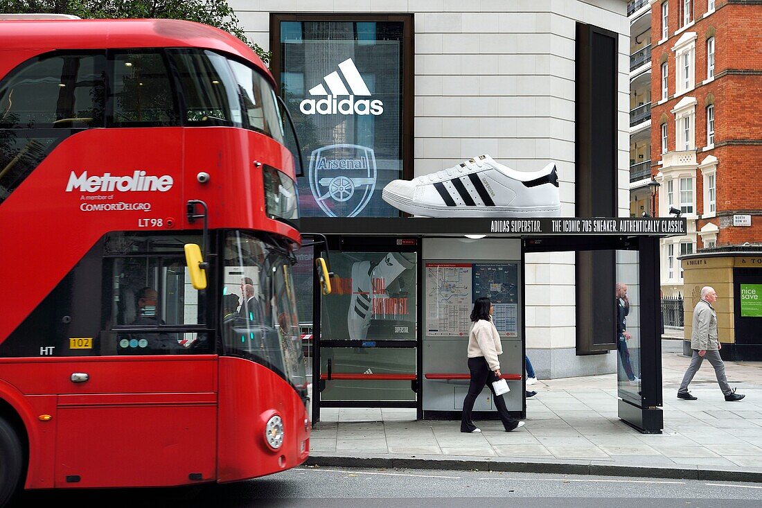 United Kingdom, London, giant shoe perched on a bus shelter for adidas advertising in Oxford street