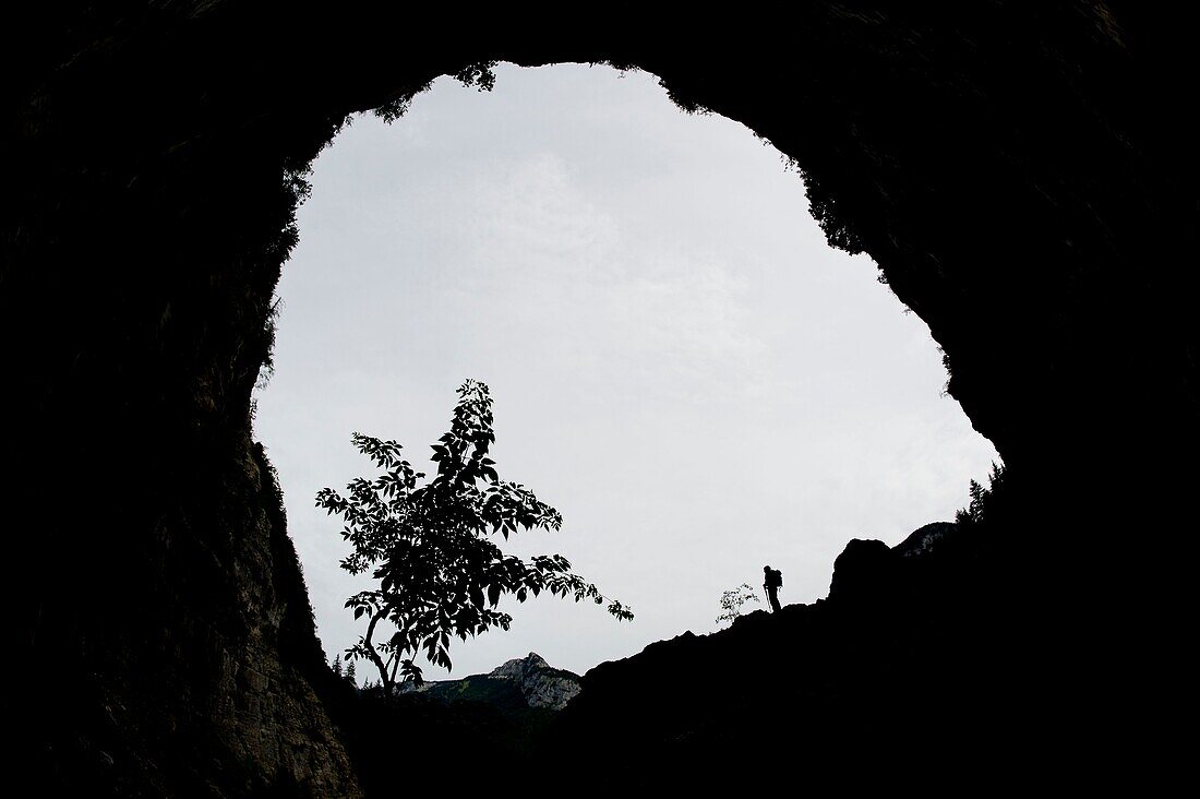 Frankreich, Haute Savoie, Bornes-Massiv, Glieres, Wanderung Tag 1, Durchgang zur Diau-Höhle, natürliches Wiederaufleben des Abflusses aus der Parmelan-Hochebene, eine Figur gibt den Maßstab für die Höhe des Höhlenvorbaus vor