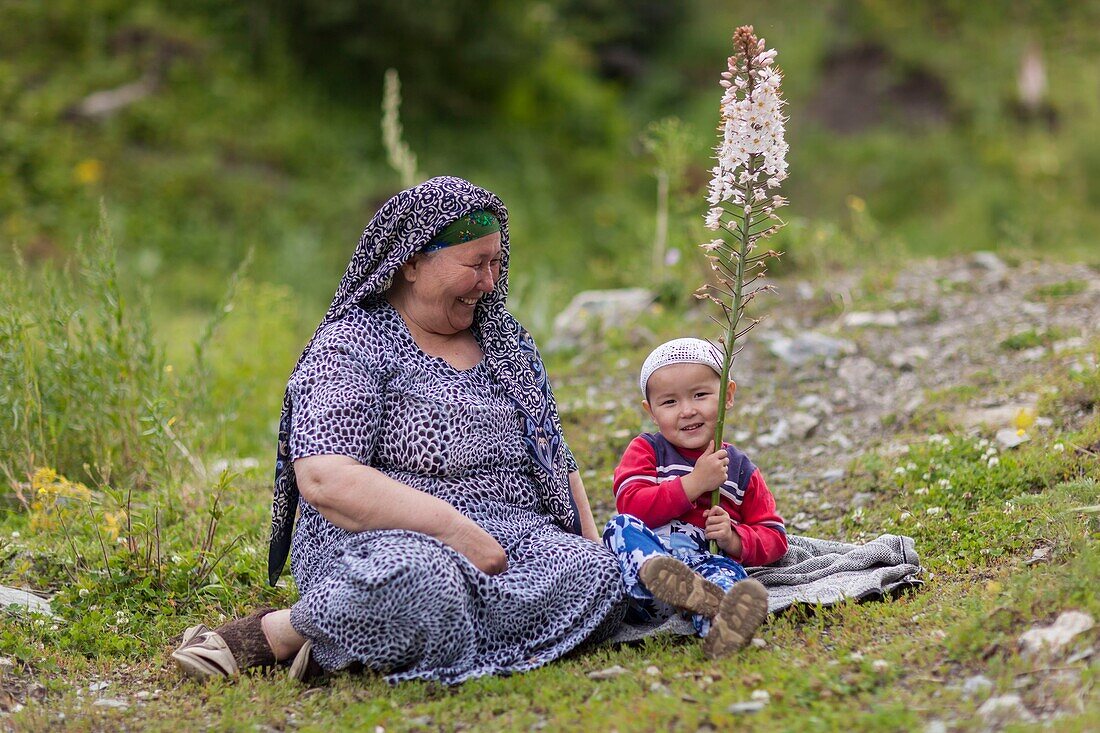 Kyrgyzstan, Naryn province, Kyrgyz woman wearing a veil and boy wearing a cap