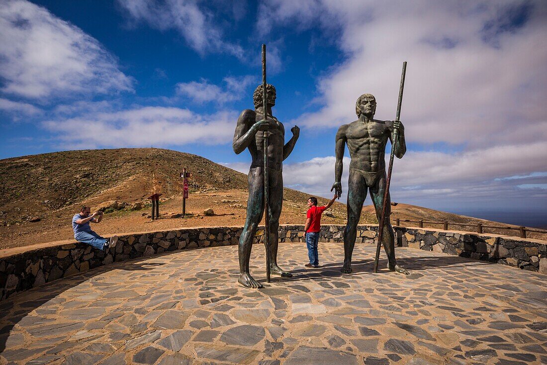 Spanien, Kanarische Inseln, Insel Fuerteventura, Betancuria, Mirador de Morro Velosa, Staue, die die vorspanischen Guanchenkönige Ayoze und Guize darstellen, mit Besuchern