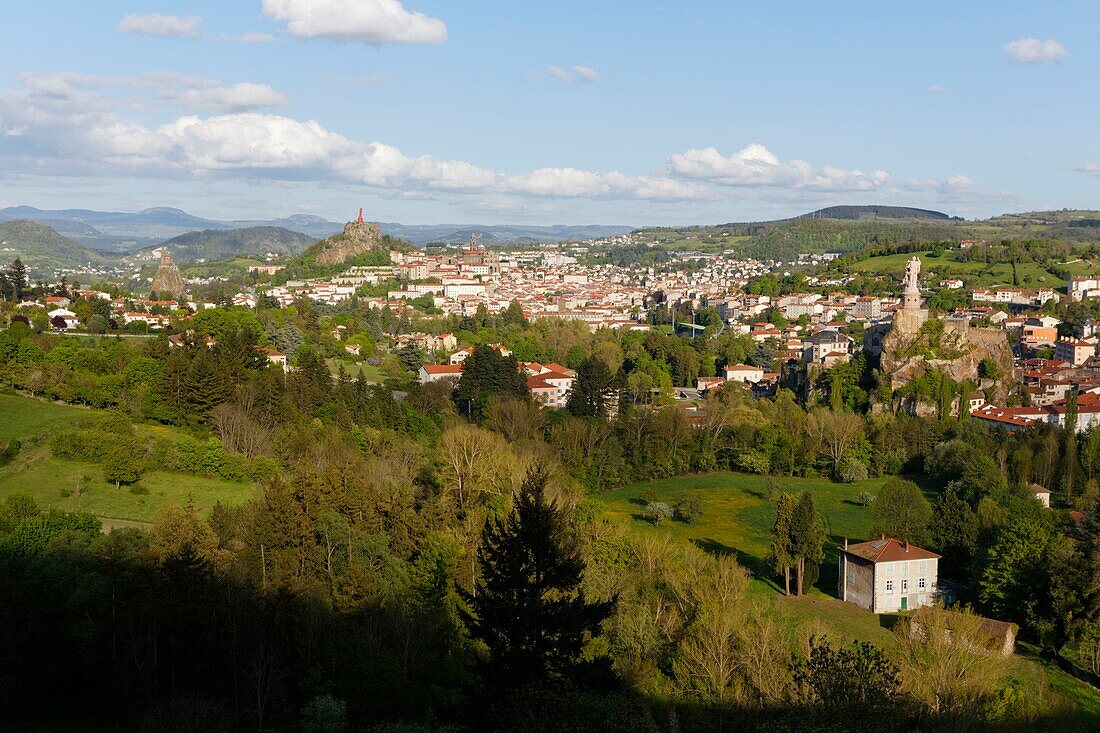 France, Haute Loire, Le Puy en Velay, a stop on el Camino de Santiago, overview of the city with Saint-Michel d'Aiguilhe on the left, Notre Dame de France statue at the top of on Rocher Corneille, Notre Dame de l'Annonciation Cathedral listed as World Heritage by UNESCO and Saint-Joseph statue on the right