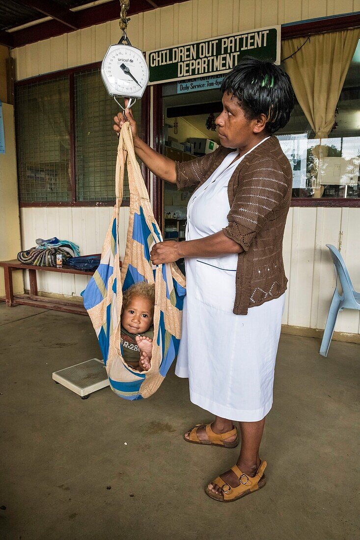 Papua-Neuguinea, Südliche Hochlandprovinz, Mendi, Mendi General Hospital, Personal kontrolliert das Gewicht eines Babys