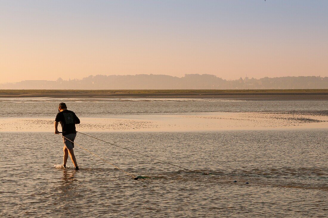 Frankreich, Somme, Baie de Somme, Le Crotoy, im Gegensatz zu den meisten Fischern, die ein Netz verwenden, das vor einem hergeschoben wird, verwendet dieser Küstenfischer eine Art Minischleppnetz, das wir hinter uns herziehen