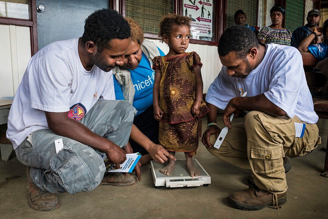 Papua-Neuguinea,Südliche Hochlandprovinz,Mendi,Mendi General Hospital,UNICEF-Mitarbeiter helfen bei der Gewichtskontrolle eines jungen Mädchens